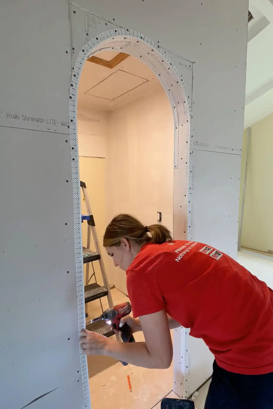 Adding corner bead while drywalling an arched doorway.
